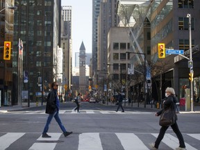 Morning commuters cross Yonge Street at Bay Street in the financial district of Toronto,
