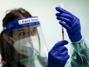 A medical worker prepares a dose of vaccine against the COVID-19 on March 13, 2021 at the local health authority (ASL) offices in Dronero, Maira Valley, near Cuneo, Northwestern Italy, as part of a home vaccination campaign