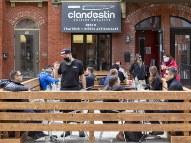 OTTAWA -- Le Clandestin chef/owner Eric Duchesne (standing left) is happy that he is able to re-open his patio on Laval Street in Gatineau. Friday, May. 28, 2021 -- . ERROL MCGIHON, Postmedia
