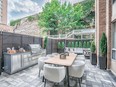 This condo balcony has multiple zones, including a sitting area, a barbecue and dining space, and an intimate seating area.