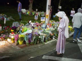Supporters light candles and place flowers at a memorial in London, Ont., following a vehicular attack that killed four members of a local Muslim family.