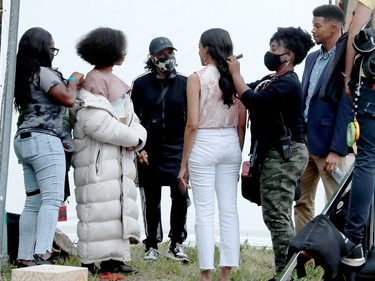 Here, co-stars Bresha Webb (second from left) and Getenesh Berhe (centre right) get tended to by a hair and makeup team while talking to the director (centre) before shooting a scene.