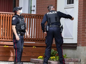 Police inspect apparent bullet holes in a house on Halifax Drive, following a gun call at a high rise building on Halifax Drive, Friday. A man was later found dead in the apartment/
