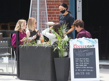 OTTAWA -June 11, 2021 --A waitress brings out food to patio goers at Johnny Farina on Elgin St, June 11, 2021..



Assignment 135794

Jean Levac/Ottawa Citizen



ORG XMIT: 135794
