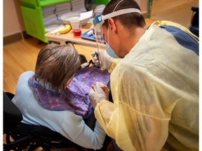 A Canadian soldier helps a senior citizen with her meal on May 8, 2020, at the Grace Dart Long-Term Care Centre in Verdun, Quebec.