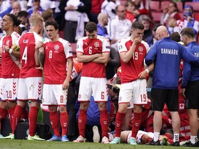 Denmark's players react as paramedics attend to Denmark's midfielder Christian Eriksen after he collapsed on the pitch during the UEFA EURO 2020 Group B football match between Denmark and Finland at the Parken Stadium in Copenhagen on June 12, 2021.