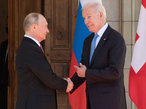 TOPSHOT - US President Joe Biden and Russian President Vladimir Putin shake hands as they arrive at Villa La Grange in Geneva, for the start of their summit on June 16, 2021.