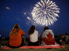 People watch fireworks fly over Ashbridges Bay in Toronto during Canada Day festivities on July 1, 2019.