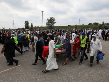 People transport a flag-wrapped coffin, outside the Islamic Centre of Southwest Ontario, during a funeral of the Afzaal family that was killed in what police describe as a hate-motivated attack, in London, Ontario, Canada June 12, 2021. REUTERS/Carlos Osorio ORG XMIT: GDN