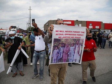 A man holds a banner after a funeral of the Afzaal family that was killed in what police describe as a hate-motivated attack, outside the Islamic Centre of Southwest Ontario, in London, Ontario, Canada June 12, 2021. REUTERS/Carlos Osorio ORG XMIT: GDN