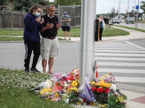 Abdullah Alzureiqi and his daughter Hala say a prayer at the fatal crime scene where a man driving a pickup truck jumped the curb and ran over a Muslim family in what police say was a deliberately targeted anti-Islamic hate crime, in London, Ontario, Canada June 7, 2021.