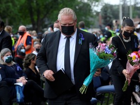 Ontario Premier Doug Ford walks to place flowers at a vigil outside the London Muslim Mosque organized after four members of a Canadian Muslim family were killed in what police describe as a hate-motivated attack in London, Ontario, Canada, June 8, 2021.