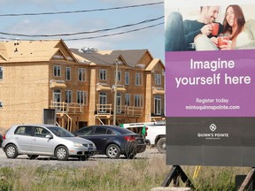 A real estate sign stands in front of new homes being constructed in Ottawa, Ontario, Canada, May 27, 2021.