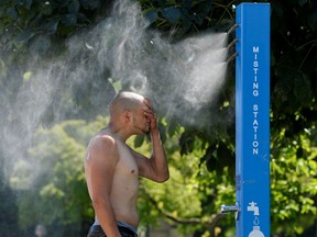 A man cools off at a misting station during the scorching weather of a heatwave in Vancouver, British Columbia, Canada June 27, 2021.