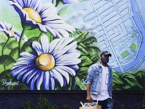 A man walks past a mural as he shops in the Glebe, one of Ottawa's more walkable neighbourhoods.