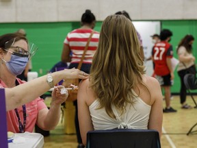 An adolescent receives a dose of the Pfizer-BioNTech Covid-19 vaccine at a clinic in Toronto