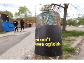 A sticker raising awareness about opioids in an alley.