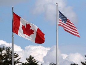 FILE PHOTO: A U.S. and a Canadian flag flutter at the Canada-United States border crossing at the Thousand Islands Bridge, which remains closed to non-essential traffic to combat the spread of the coronavirus disease (COVID-19) in Lansdowne, Ontario, Canada.