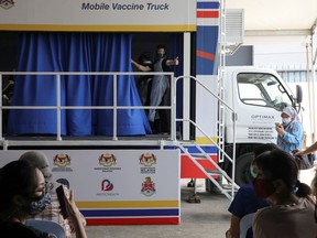 A medical worker gestures inside a coronavirus disease (COVID-19) vaccination truck in Kuala Lumpur, Malaysia June 8, 2021.