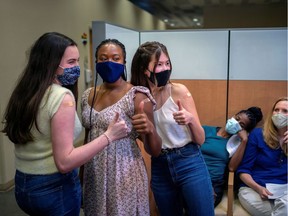 FILE PHOTO: Three teenage girls give a thumbs up after they received their first dose of the COVID-19 vaccine.