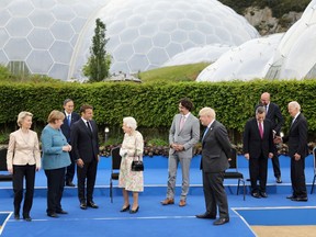 European Commission President Ursula von der Leyen, German Chancellor Angela Merkel, Japan's Prime Minister Yoshihide Suga, France's President Emmanuel Macron with Britain's Queen Elizabeth, Canada's Prime Minister Justin Trudeau,  Britain's Prime Minister Boris Johnson, Italy's Prime Minister Mario Draghi, U.S. President Joe Biden and European Council President Charles Michel prepare for a group photo during a drinks reception on the sidelines of the G7 summit, at the Eden Project in Cornwall, Britain June 11, 2021.