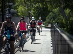 Cyclists crossing the bridge above the Rideau Falls, Saturday, July 10, 2021.