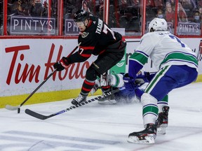 Files: Ottawa Senators left wing Brady Tkachuk (7) flattens Vancouver Canucks center Brandon Sutter (20) and controls the puck against center Zack MacEwen (71) during first period NHL action at the Canadian Tire Centre, Apr. 28, 2021.