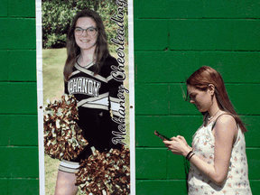 Former student cheerleader Brandi Levy stands in front of her cheerleading poster in Mahanoy, Pennsylvania.