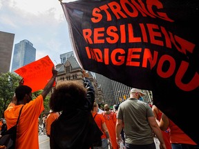 People march in honour of the victims and survivors of Canada's residential school system, in Toronto on Canada Day, July 1, 2021. Tasha Kheiriddin suggests Indigenous Canadians form a political party to further their interests at Parliament.