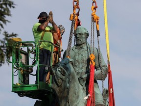 A worker gesture as he removes a statue of Confederate General Robert E. Lee. after years of a legal battle over the contentious monument, in Charlottesville, Virginia.