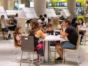 People eat in the foodcourt at the Eaton Centre shopping centre after indoor dining restaurants, gyms and cinemas re-open under Phase 3 rules in Toronto, Ontario, Canada July 31, 2020