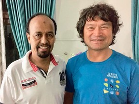 In this undated photo released by the Pakistan Alpine Club on Tuesday, July 20, 2021, shows club's secretary Karrar Haidri, left, and the now missing Korean climber Kim Hong Bin posing for a photograph, in Islamabad, Pakistan.