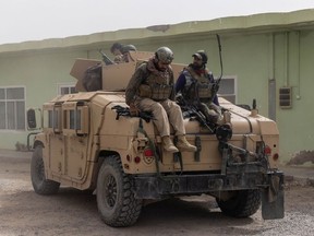 Members of the Afghan Special Forces climb down from a humvee as they arrive at their base after heavy clashes with Taliban in Kandahar province, Afghanistan, July 13, 2021.