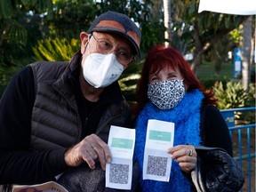 Files: Israelis shows their "green pass" (proof of being fully vaccinated against the coronavirus) before entering the Green Pass concert for vaccinated seniors in Feb, 2021.