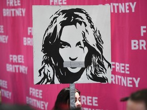 Files: A woman holds a poster of Britney with her mouth taped shut as fans and supporters gather outside the Los Angeles County Courthouse in Los Angeles on July 14, 2021, during a scheduled hearing in the Britney Spears guardianship case. - Three weeks after Britney Spears sensationally called for an end to her "abusive" guardianship, the pop singer's legal battle returns to court July 14 in Los Angeles.