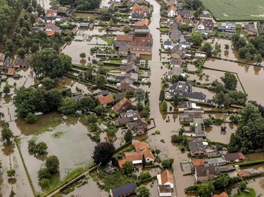TOPSHOT - This aerial view taken in Brommelen on July 16, 2021 shows the flooded area around the Meuse after a levee of the Juliana Canal broke. - The death toll from devastating floods in Europe soared to at least 126 on July 16, 2021, most in western Germany where emergency responders were frantically searching for missing people. In Belgium, the government confirmed the death toll had jumped to 20 - earlier reports had said 23 dead - with more than 21,000 people left without electricity in one region. (Photo by Remko de Waal / ANP / AFP) / Netherlands OUT