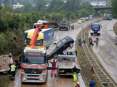 Members of the German Federal Agency for Technical Relief THW (Technisches Hilfswerk) assist in clearing the federal highway B265 of damaged vehicles in Erftstadt, western Germany, on July 17, 2021, after heavy rains hit parts of the country, causing widespread flooding and major damage.