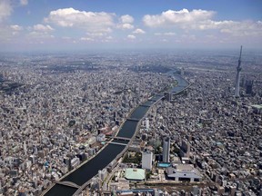 TOPSHOT - This aerial photo shows the Sumida river and the city skyline in Tokyo, ahead of the Tokyo 2020 Olympic Games, July 19, 2021.