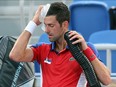 Serbia's Novak Djokovic uses ice and the air conditioner to cool himself off during his Tokyo 2020 Olympic Games men's singles third round tennis match against Spain's Alejandro Davidovich Fokina at the Ariake Tennis Park in Tokyo on July 28, 2021.