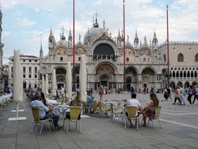 Files: People sit at a cafe in St. Mark's Square as Venice gets ready to host the world's first film festival since the coronavirus outbreak in Venice, Italy,