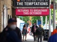 FILE PHOTO: People walk on the sidewalk past Broadway show marquees amid the coronavirus disease (COVID-19) pandemic in Manhattan, New York, U.S., May 13, 2021.