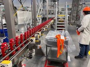 A person works with robots at Procter & Gamble's factory in Tabler Station, West Virginia, U.S., May 28, 2021. Picture taken May 28, 2021.