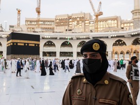 FILE PHOTO: A Saudi police female officer stands guard as pilgrims perform final Tawaf during the annual Haj pilgrimage, in the holy city of Mecca, Saudi Arabia July 20, 2021.