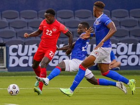 Jul 15, 2021; Kansas City, Kansas, USA; Haiti defender Alex Christian (22) fights Canada defender Richie Laryea (22) for the ball as defender Francois Dulysse (3) supports during CONCACAF Gold Cup Soccer group stage play at Children's Mercy Park.