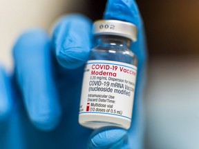 Files: A health worker holds a vial of the Moderna Inc. Covid-19 vaccine