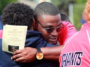 Hundreds of people showed up on Friday, July 16, 2021 for a celebration of life to honour Loris Tyson Ndongozi at the football field Tyson knew and loved. Former teammates give each other a hug before the celebration.