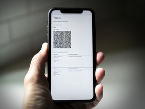 A cell phone displays a QR code proof of vaccination