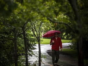 FILE: A man walks on the Rideau River Eastern Pathway in Riviera Park as Ottawa was hit with a dreary and wet day.