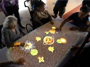 Residents interact with the Tovertafel at the Maimonides Geriatric Centre on Wednesday. Developed in the Netherlands, it has shown promise in physical activity as well as social interaction for those with dementia.