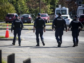 Members of the Ottawa police's emergency services unit were combing through the parking lot area of Greenboro Community Centre, Monday, August 30, 2021